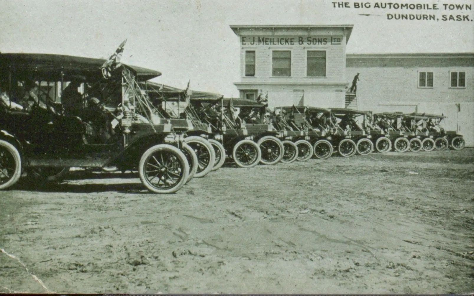 Row of early automobiles outside E. J. Meilicke & Sons, Dundurn