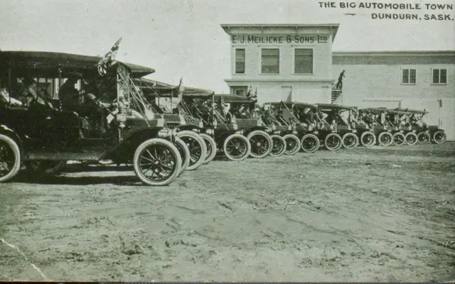 Row of early automobiles outside E. J. Meilicke & Sons, Dundurn