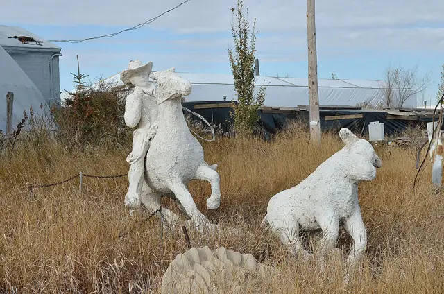 Cowboy and calf statues in the grass